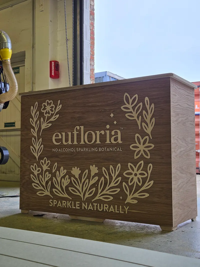 Timber display bar with an engraved floral brand design
