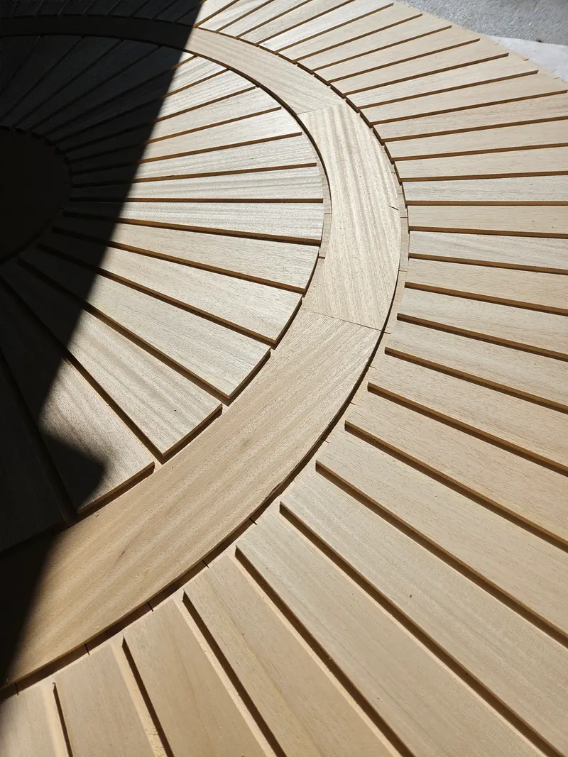 Radial timber sauna ceiling with slats fanning out around a curved ring